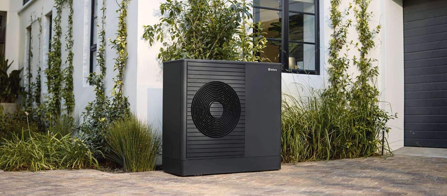 A heat pump outdoor unit in front of a house
